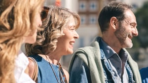 Tre persone anziane sorridono al sole